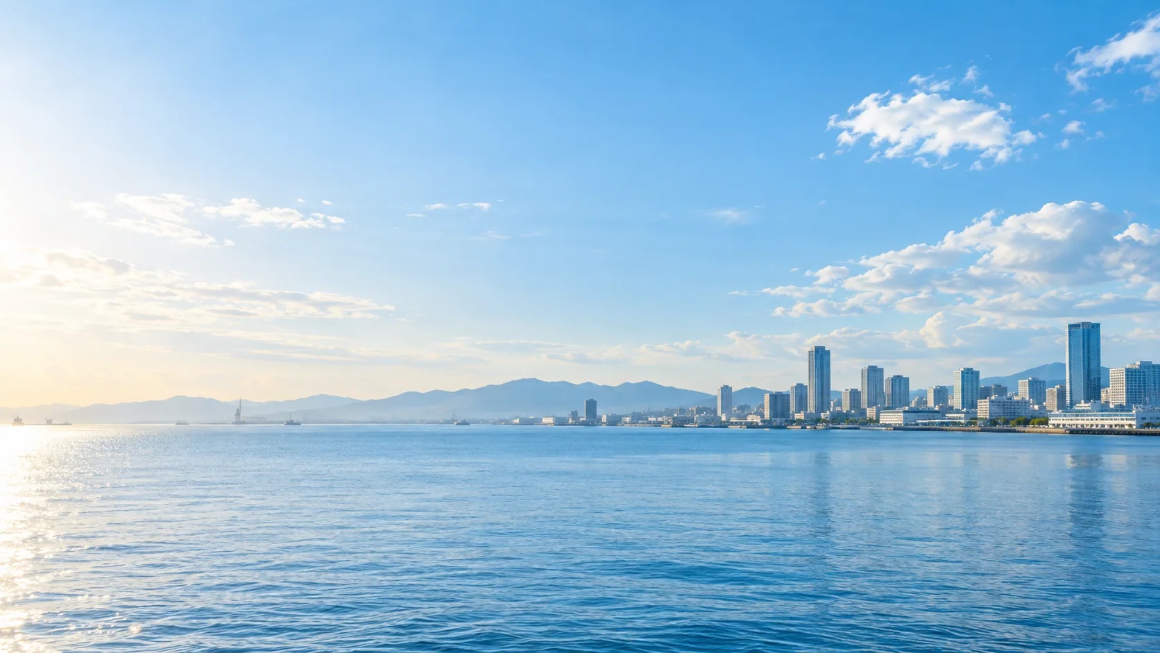 明るい空と穏やかな海、その先に広がる街並み